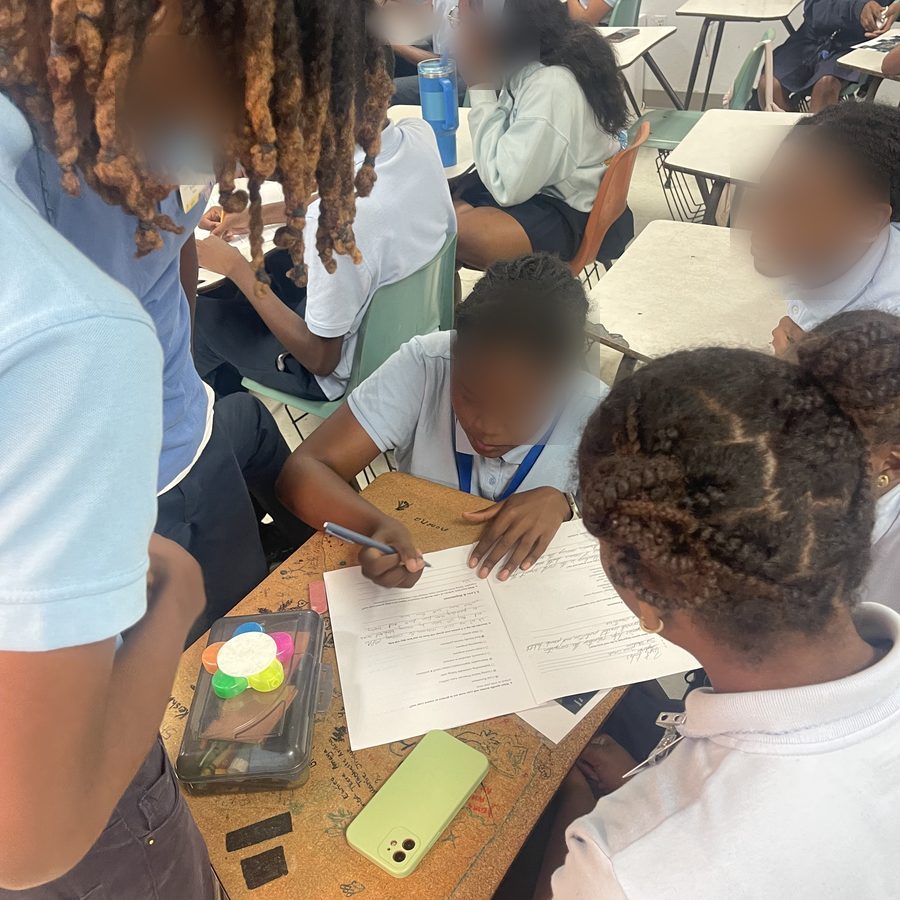 Students gathered around a desk filling in a coral reef worksheet together